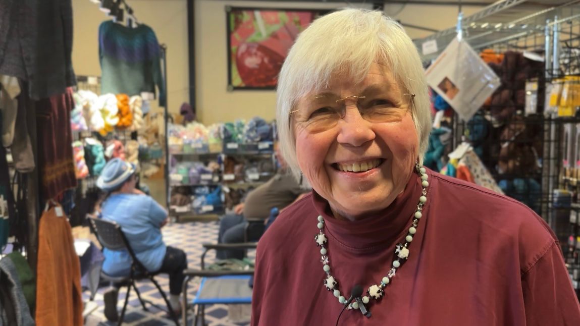 Carolyn Beasley is all smiles in her booth at the 18th annual Carolina FiberFest. (Spectrum News 1/Rachel Boyd)