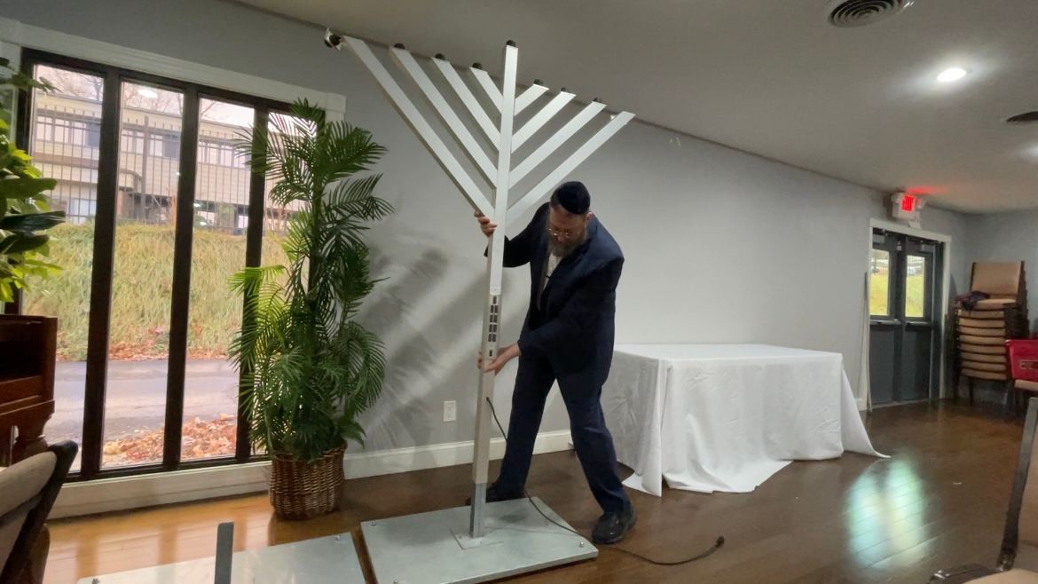 Rabbi Shaya Susskind pieces together a 6-foot menorah before Hanukkah begins (Samantha Narson/Spectrum News 1)