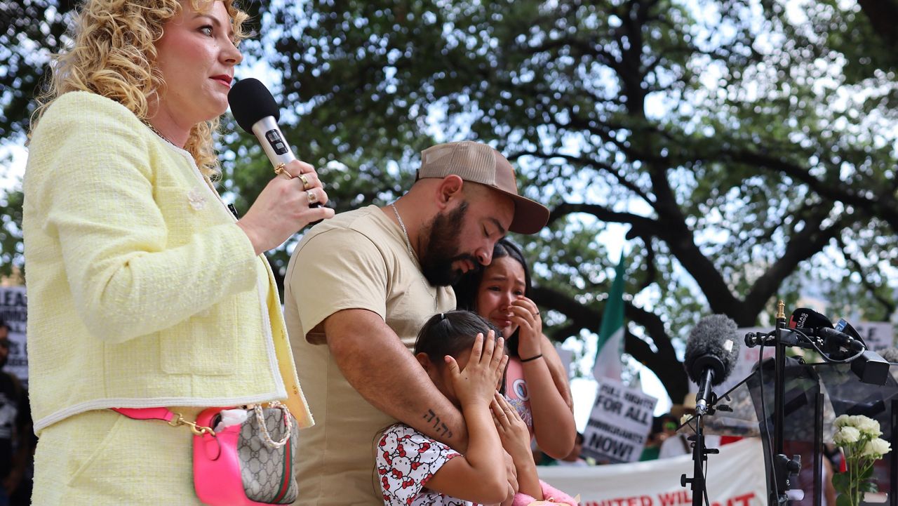 Kate Lincoln-Goldfinch with her client Carmen's family. Carmen has been one of many migrants detained outside of immigration court. (Spectrum News 1/Jose Arredondo)
