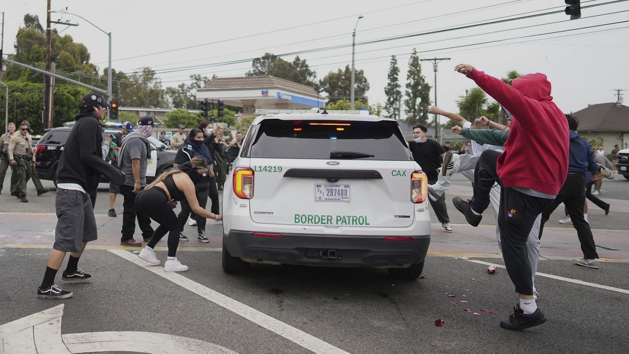 Protesters kick the side of a Border Patrol vehicle during a demonstration over the dozens detained in an operation by federal immigration authorities a day earlier, in Paramount, Calif., Saturday, June 7, 2025. (AP Photo/Eric Thayer)