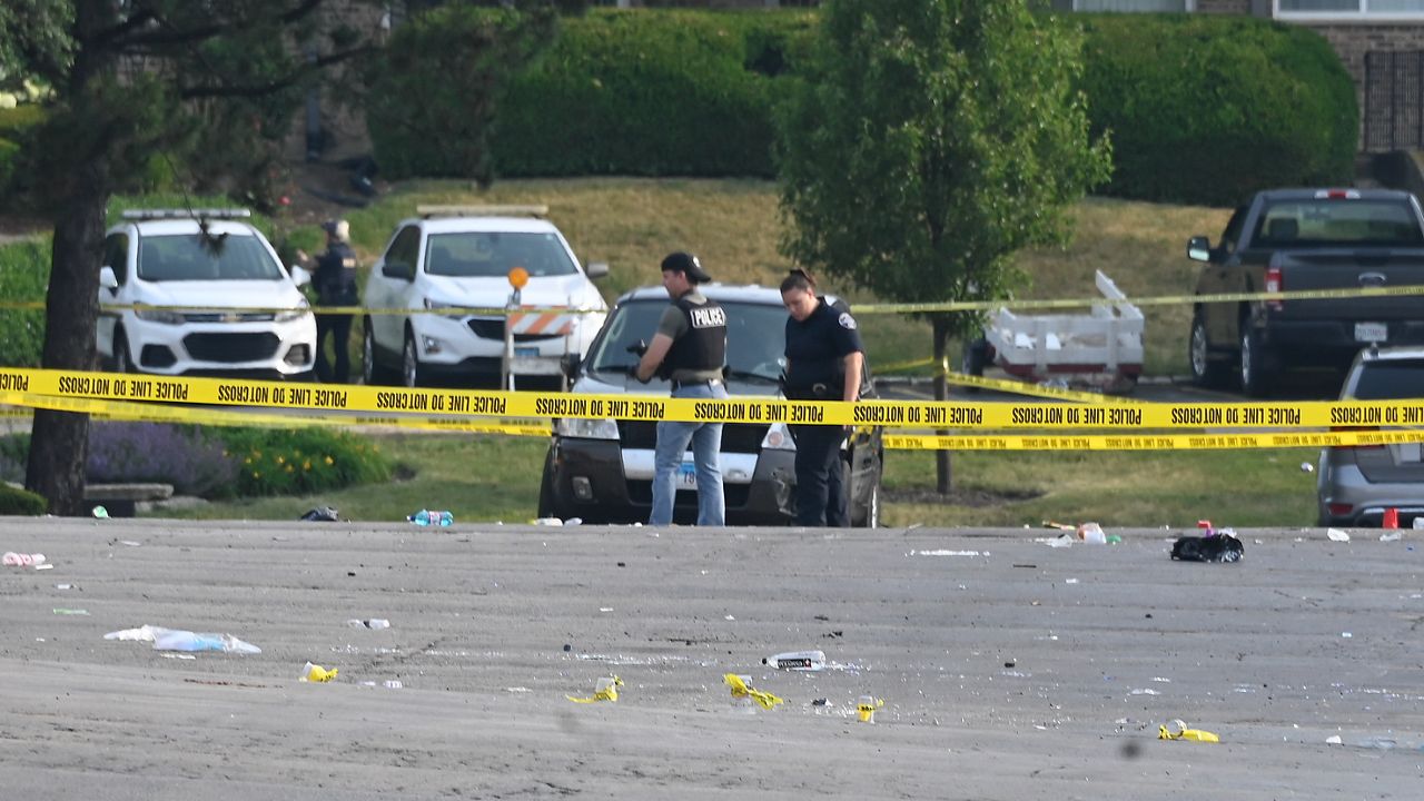 Investigators look over the scene of an overnight mass shooting at a strip mall in Willowbrook, Ill., Sunday, June 18, 2023. (AP Photo/Matt Marton)