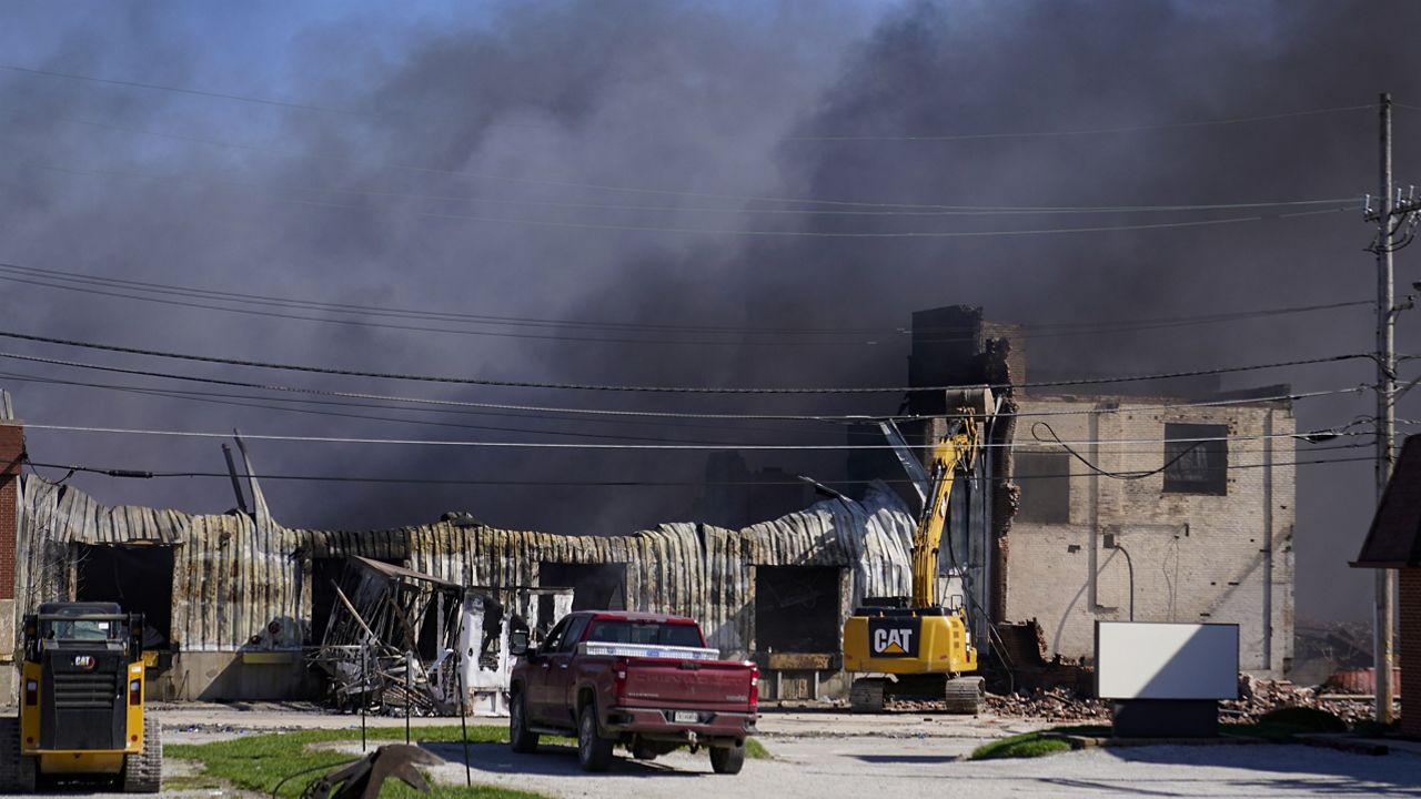 Workers knock down a section of site of an industrial fire the area as smoke billows from the site in Richmond, Ind., Wednesday, April 12, 2023. (AP Photo/Michael Conroy)