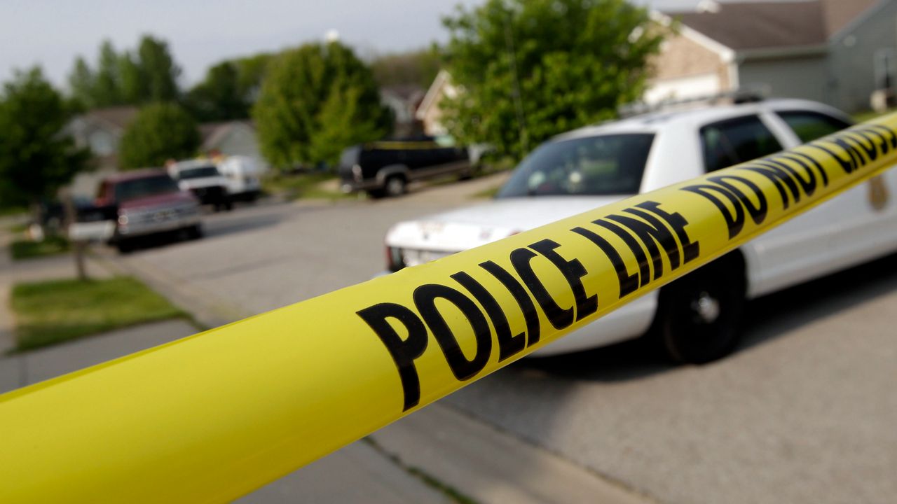 Police tape blocks the street in front of the scene of a shooting in the Lakeside Manor neighborhood of Indianapolis on Tuesday, May 20, 2014. (AP Photo/AJ Mast)