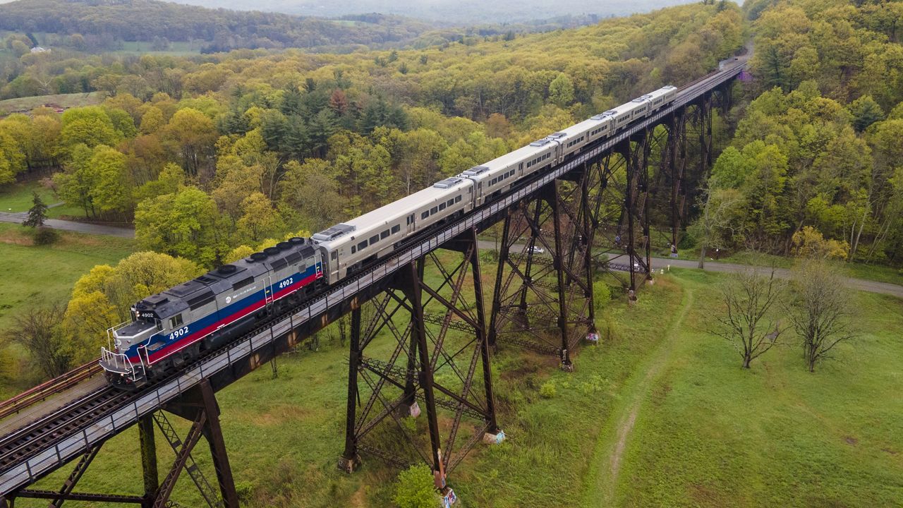 A Metro-North Railroad passenger train travels on the Moodna Viaduct steel railroad trestle in Cornwall, New York, on Thursday, April 27, 2023. (AP Photo/Ted Shaffrey)