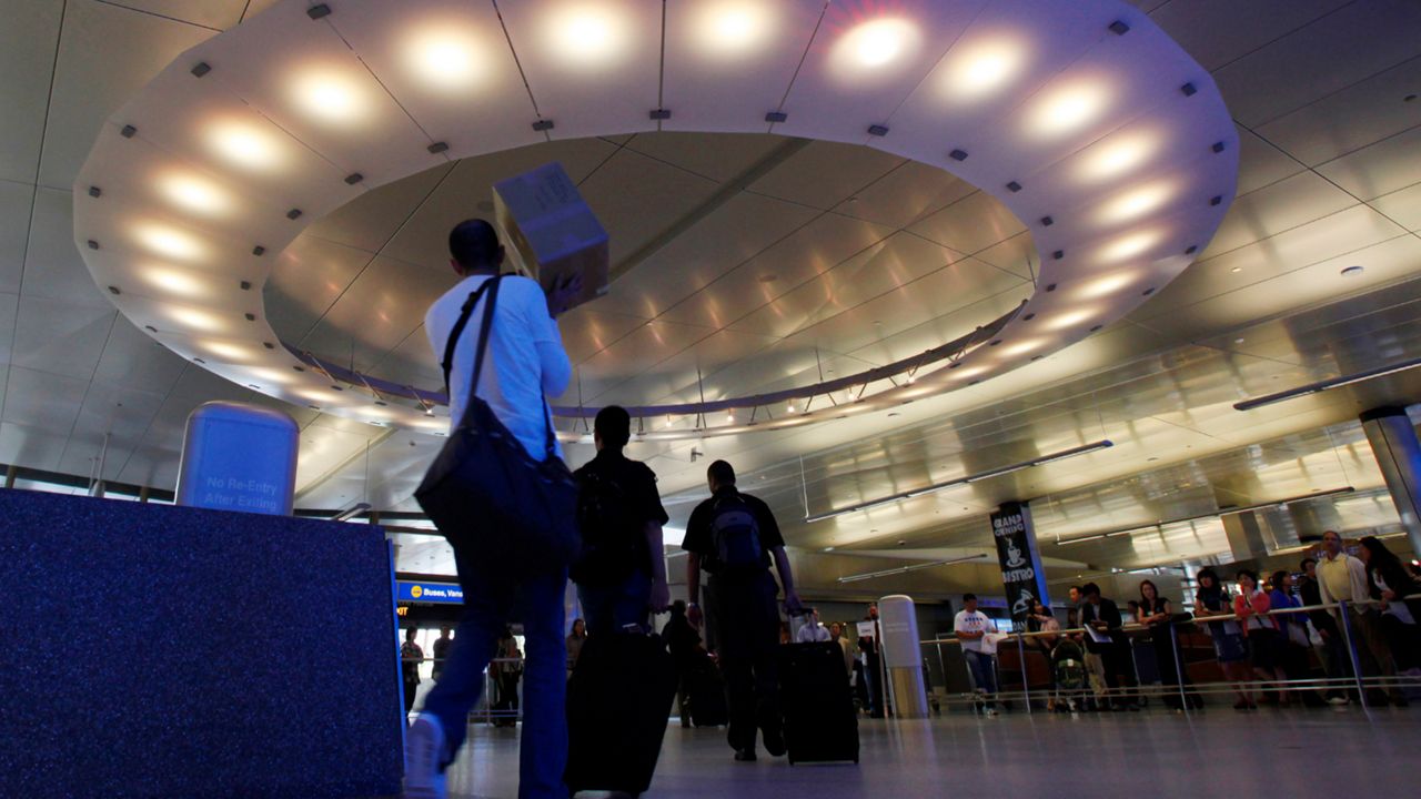 Arriving international passengers pass under a large "halo" of light in the area where they meet friends and family, at the customs clearance area at the Tom Bradley International Terminal at Los Angeles International Airport, May 28, 2010. Three Muslim Americans have filed a lawsuit alleging that U.S. border officers questioned them about their religious beliefs in violation of their constitutional rights when they returned from international travel. The three men from Minnesota, Texas and Arizona sued Department of Homeland Security officials on Thursday, March 24, 2022, in a federal court in Los Angeles. The suit was filed in California because some of the questioning allegedly occurred at Los Angeles International Airport. (AP Photo/Reed Saxon, File)