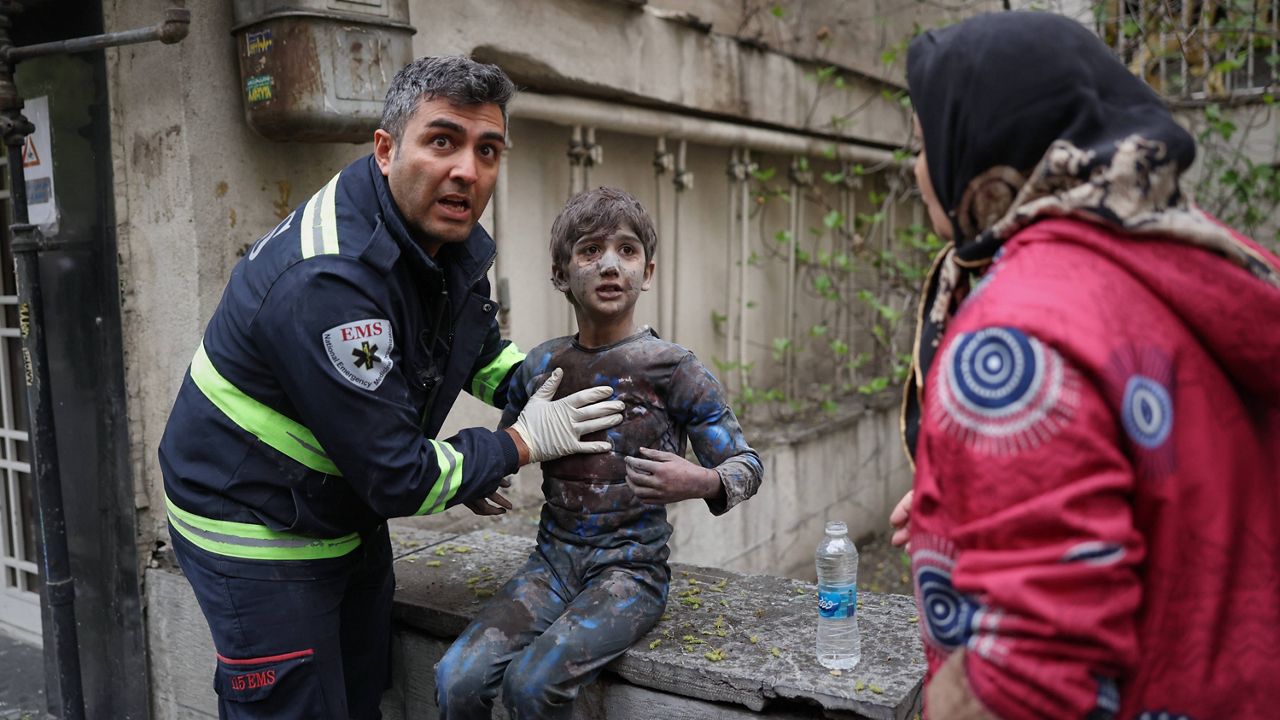 शनिवार, 28 मार्च, 2026 को तेहरान, ईरान में अमेरिकी-इजरायली सैन्य अभियान के बीच एक आवासीय इमारत पर हुए हमले के बाद एक घायल लड़के की सहायता करता पहला प्रत्युत्तरकर्ता। (एपी फोटो/सजाद सफारी)