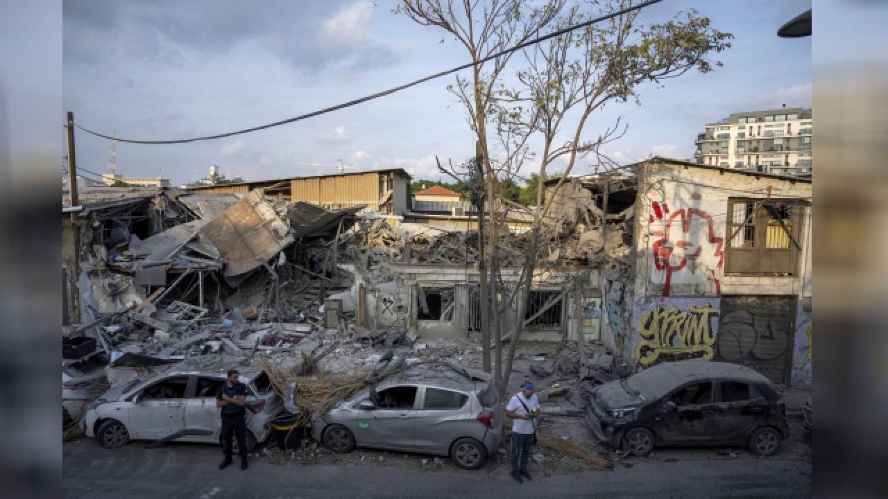 Israelis inspect the rubble of a building a day after it was hit by a rocket fired from the Gaza Strip, in Tel Aviv, Israel, Sunday, Oct. 8, 2023. The militant Hamas rulers of the Gaza Strip carried out an unprecedented, multi-front attack on Israel at daybreak Saturday, firing thousands of rockets as dozens of Hamas fighters infiltrated the heavily fortified border in several locations by air, land, and sea, killing hundreds and taking captives. Palestinian health officials reported scores of deaths from Israeli airstrikes in Gaza. (AP Photo/Oded Balilty)