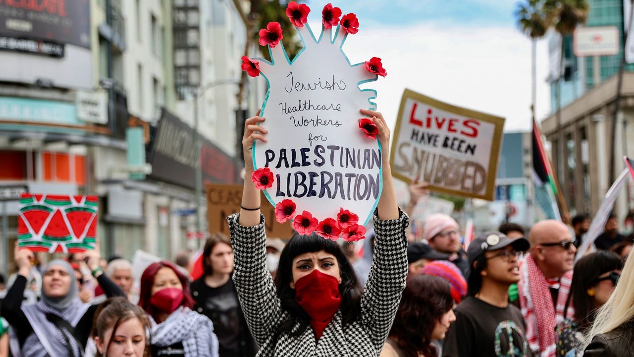 A protester holds a poster during a demonstration in support of Palestinians calling for a ceasefire in Gaza as the 96th Academy Awards Oscars ceremony is held nearby, Sunday, March 10, 2024, in the Hollywood section of Los Angeles. (AP Photo/Etienne Laurent)