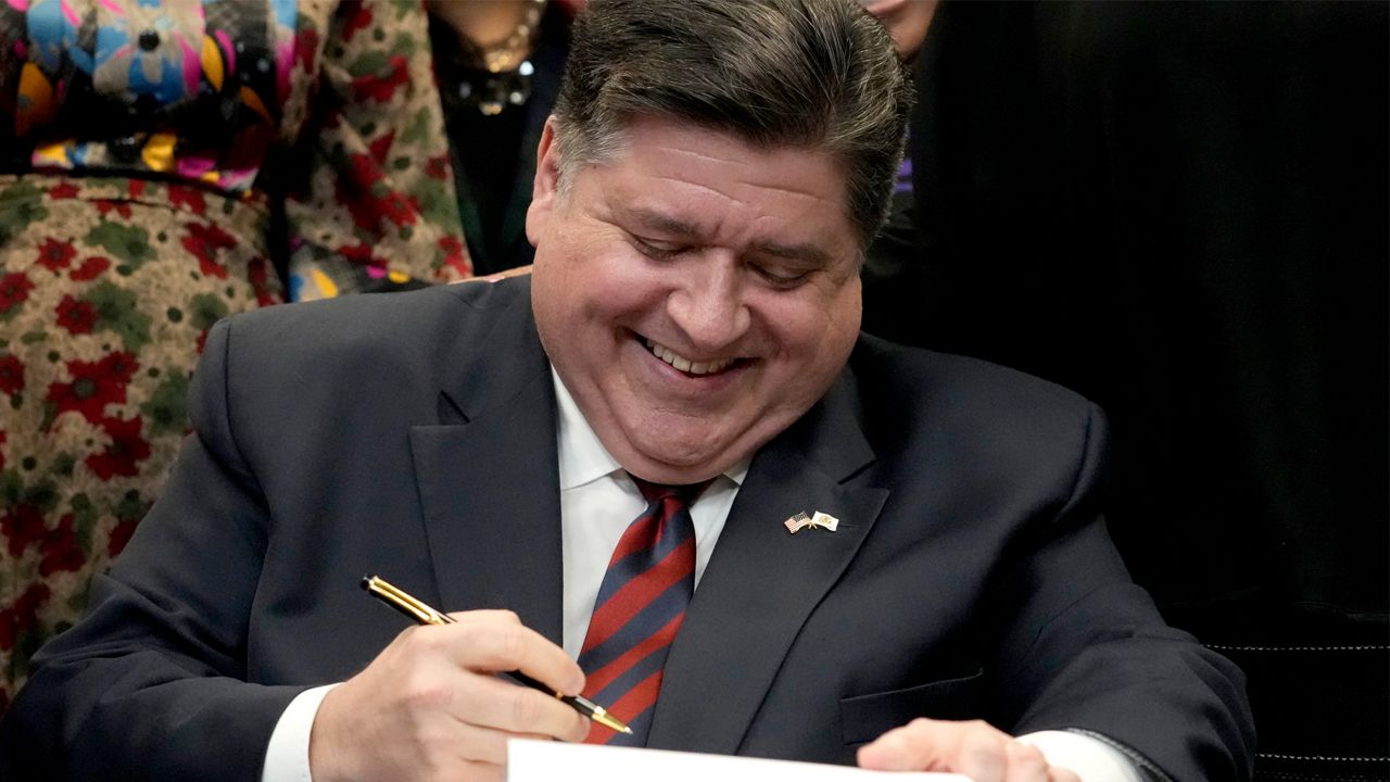 Illinois Gov. J.B. Pritzker signs into law the Paid Leave For All Workers Act on Monday, March 13, 2023, in Chicago. Illinois became one of three U.S. states to require employers to offer paid time off for any reason starting in January of 2024. (AP Photo/Charles Rex Arbogast)