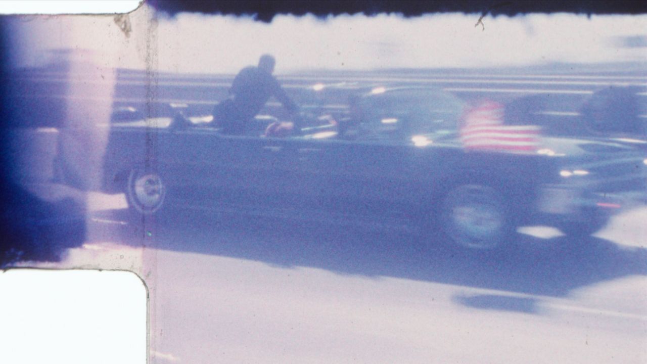 An undated image released by RR Auction shows home film footage of President John F. Kennedy's motorcade speeding down a Dallas freeway to the hospital after he was fatally wounded on Nov. 22, 1963. The image comes from a home film taken by Dale Carpenter Sr., which will go up for auction later this month. (RR Auction via AP)