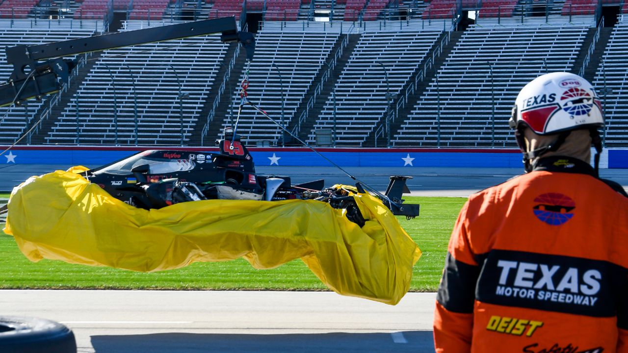 A wrecker carries away Jack Harvey's car after an accident during the final practice round of an IndyCar Series auto race at Texas Motor Speedway in Fort Worth, Texas, Saturday, March 19, 2022. (AP Photo/Randy Holt)