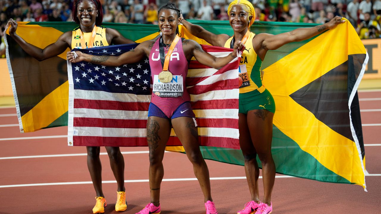 Silver medalist Shericka Jackson, of Jamaica, gold medalist Sha'Carri Richardson, of the United States, and bronze medalist Shelly-Ann Fraser-Pryce, of Jamaica, from left, pose after the Women's 100-meter final during the World Athletics Championships in Budapest, Hungary, Monday, Aug. 21, 2023.(AP Photo/Bernat Armangue)