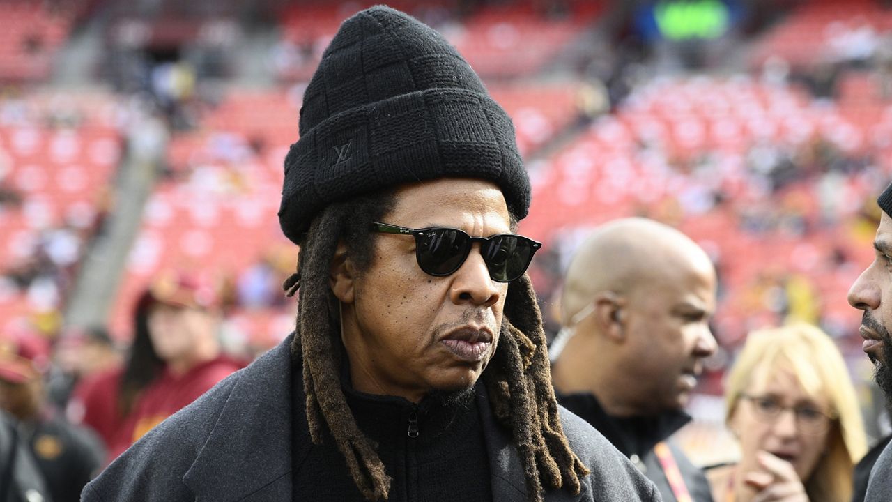 Musician Jay-Z stands on the field before an NFL football game between the Washington Commanders and Dallas Cowboys, on Nov. 24, 2024, in Landover, Md. (AP Photo/Nick Wass, File)