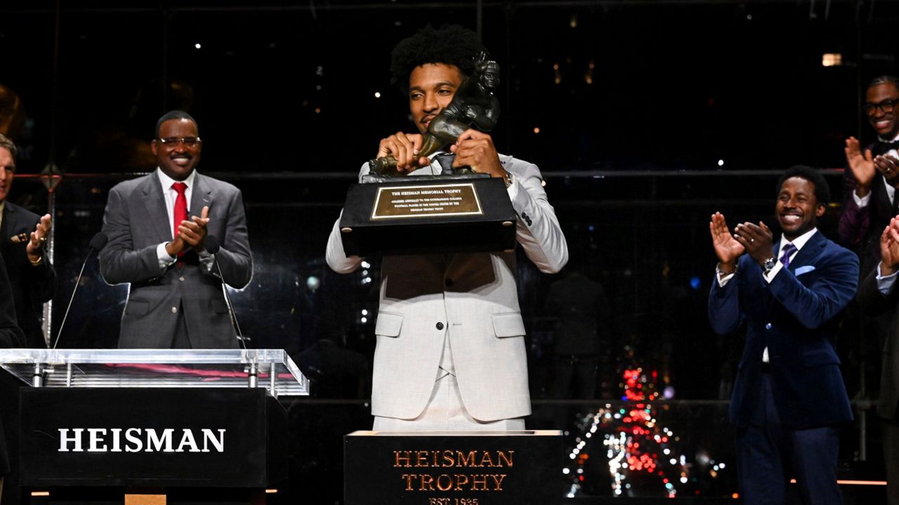 LSU quarterback Jayden Daniels lifts Heisman Trophy after winning the college football award, Saturday, Dec. 9, 2023, in New York. (Todd Van Emst/Pool Photo via AP)