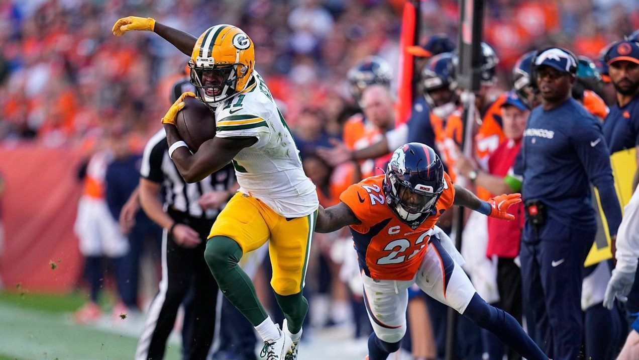 Green Bay Packers wide receiver Jayden Reed, left, runs after being pushed out of bounds by Denver Broncos safety Kareem Jackson (22) during the second half of an NFL football game in Denver, Sunday, Oct. 22, 2023. (AP Photo/Jack Dempsey)