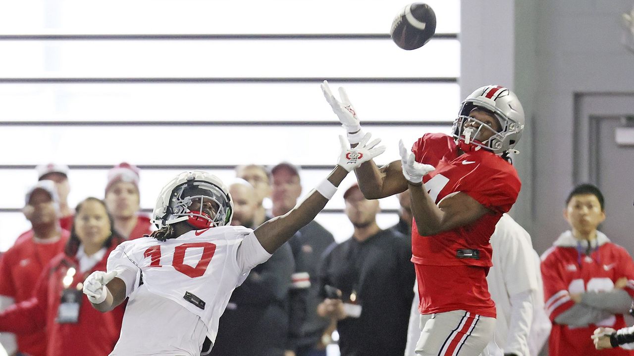 Ohio State University pass-catching prodigy Jeremiah Smith, right, and corner back Jordan Hancock battle for a pass during the NCAA college football team's fan appreciation day workout in Columbus, Ohio, March 29, 2024. (John Kuntz/Cleveland.com via AP)/Cleveland.com via AP)