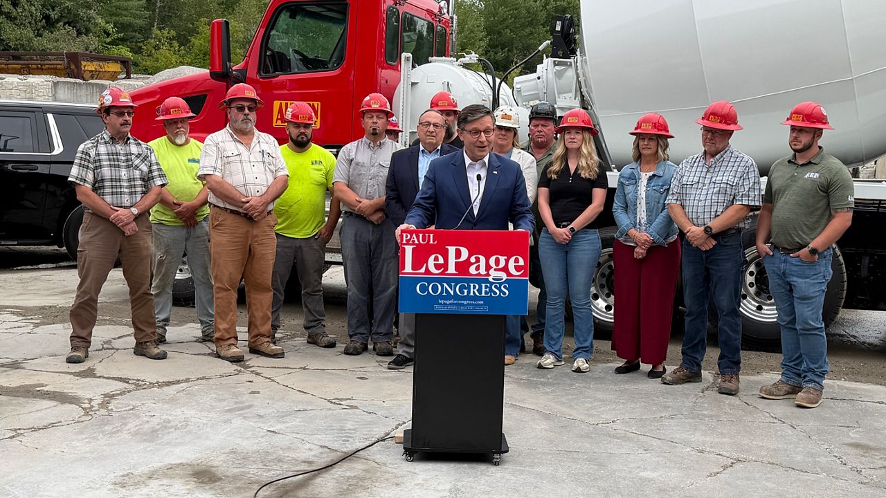 Auburn Concrete workers and former Gov. Paul LePage stand behind House Speaker Mike Johnson during a Monday press conference. (Spectrum News/Susan Cover)