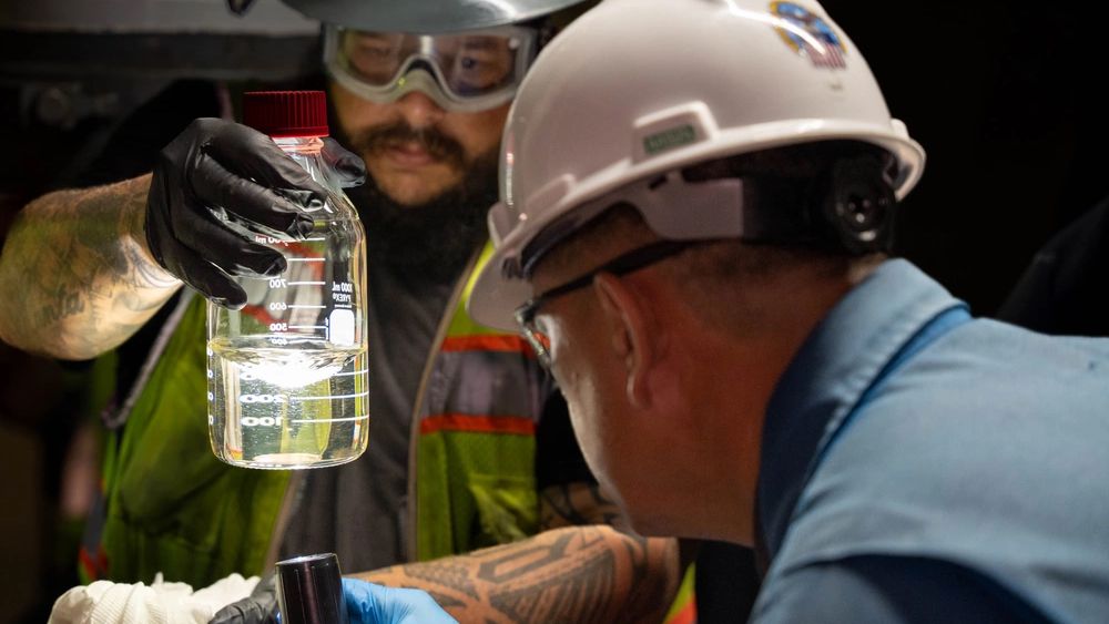 A quality assurance representative and a fuel operator with Joint Task Force-Red Hill inspect a sample of fuel at the Red Hill Bulk Fuel Storage Facility in Halawa, Hawaii, April 19, 2023. (Photo courtesy of Joint Task Force Red Hill/U.S. Marine Corps Sgt. Luke Cohen)