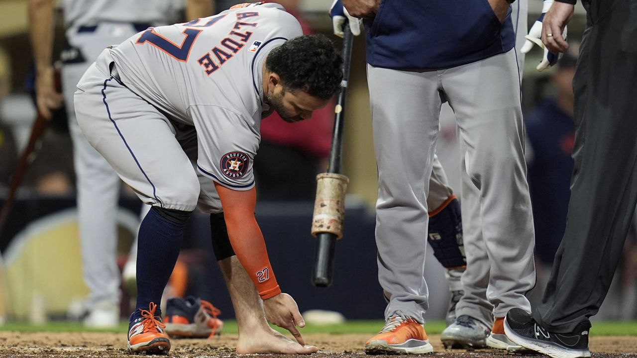 Houston Astros' Jose Altuve points at his foot after taking his sock and shoe off during the ninth inning of a baseball game against the San Diego Padres Tuesday, Sept. 17, 2024, in San Diego. Altuve was ejected along with Astros manager Joe Espada after arguing a groundout by Altuve was fouled off his foot. (AP Photo/Gregory Bull)