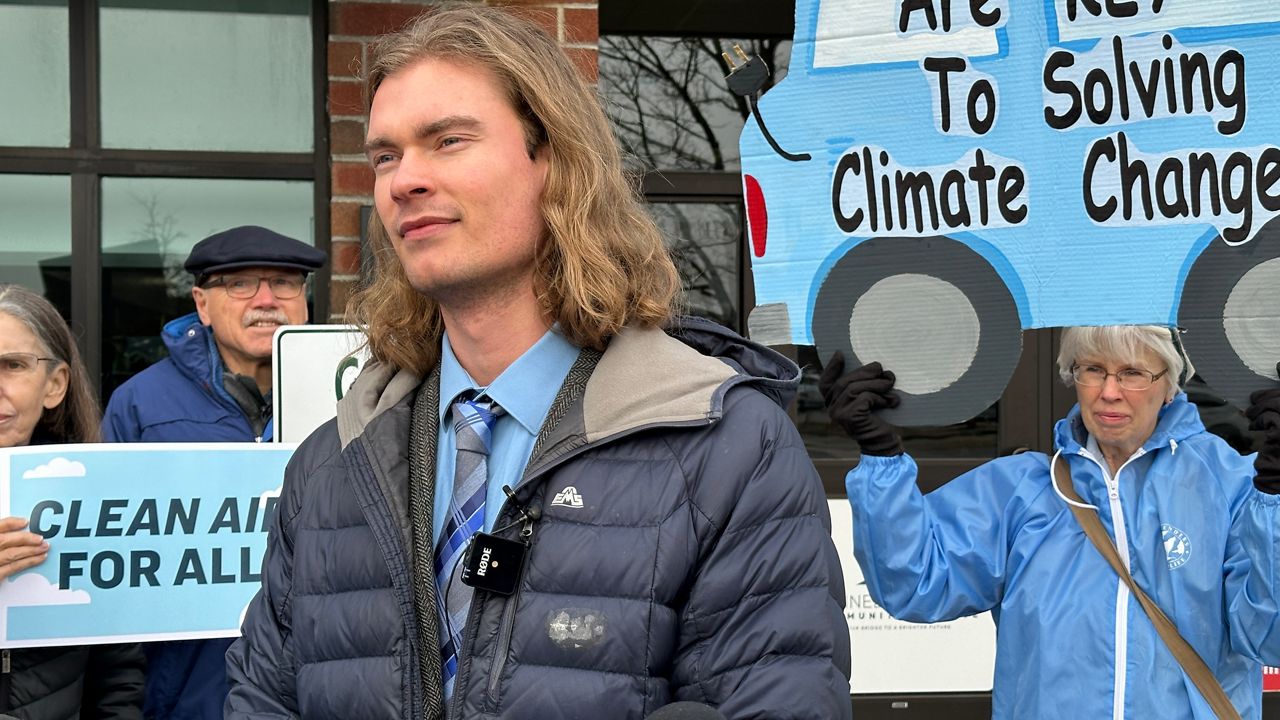 Josh Caldwell of the Natural Resources Council of Maine talks about the proposed electric vehicle rules Wednesday outside the Augusta Civic Center. (Spectrum News/Susan Cover)