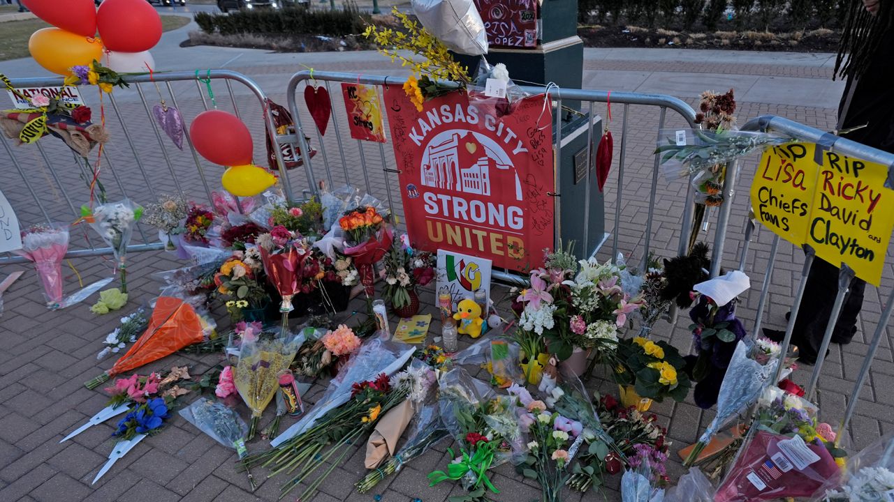 A person views a memorial dedicated to the victims of last week's mass shooting in front of Union Station, Sunday, Feb. 18, 2024, in Kansas City, Mo. Authorities say two juveniles have been charged with crimes connected to the shooting at the Kansas City Chiefs’ Super Bowl rally. (AP Photo/Charlie Riedel)