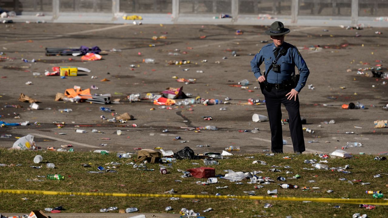 A law enforcement officer looks around the scene following a shooting at the Kansas City Chiefs NFL football Super Bowl celebration in Kansas City, Mo., Wednesday, Feb. 14, 2024. Multiple people were injured, a fire official said.(AP Photo/Charlie Riedel)