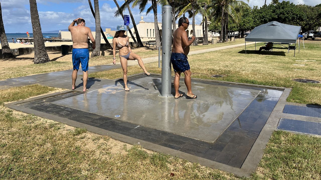 Park goers use the low-flow shower at Kaimana Beach. (Photo courtesy of Honolulu Parks & Rec)