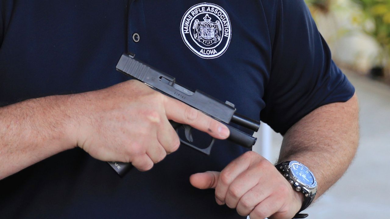 Kainoa Kaku, president of the Hawaii Rifle Association, checks one of his personal firearms as he discusses the recent Supreme Court Ruling while at his home, June, 23, 2022, in Honolulu. (AP Photo/Marco Garcia, File)