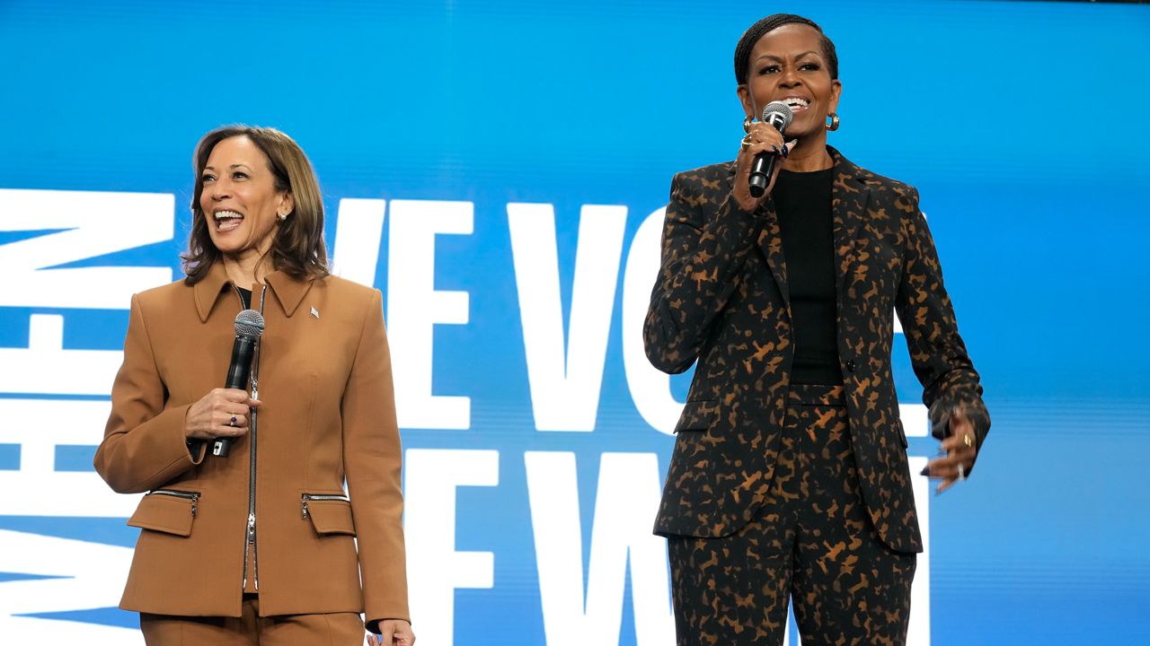 Former first lady Michelle Obama speaks as Democratic presidential nominee Vice President Kamala Harris listens at the overflow space of a campaign rally at the Wings Event Center in Kalamazoo, Mich. (AP Photo/Jacquelyn Martin)