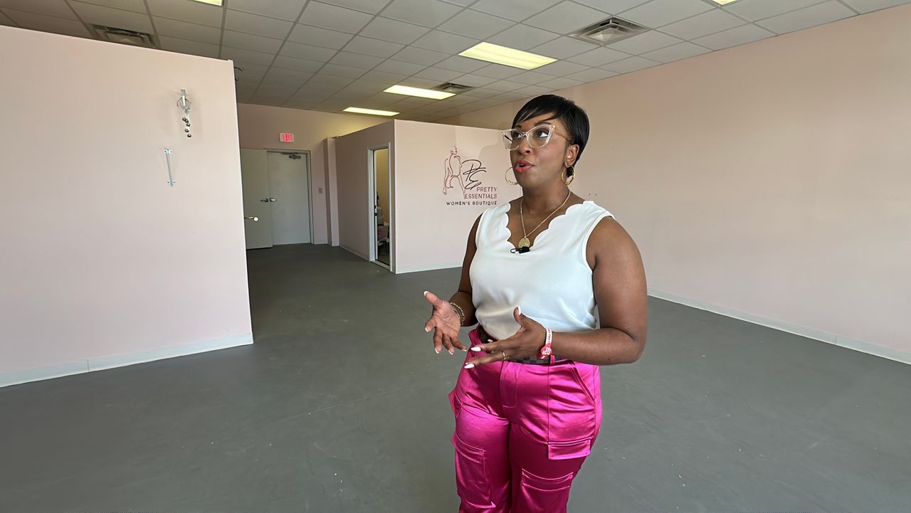 Keisha stands in her store months after being wrecked by Helene and explains the meaning behind the phrase on her wall, 'The beauty in the battle'.