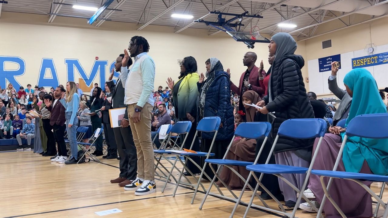 A group of 20 applicants for US citizenship took the oath swearing them in as official citizens in a ceremony Friday morning held at the Middle School of the Kennebunks in Kennebunk. More than 200 students, faculty and staff watched. (Spectrum News/Sean Murphy)