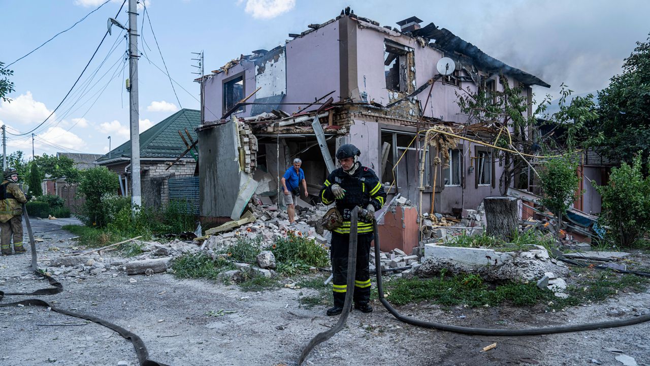A Ukrainian State Emergency Service firefighter changes his position as they put out a fire a house destroyed in a Russian shelling, in a residential neighbourhood in Kherson, Ukraine, Saturday, July 1, 2023. (AP Photo/Evgeniy Maloletka)