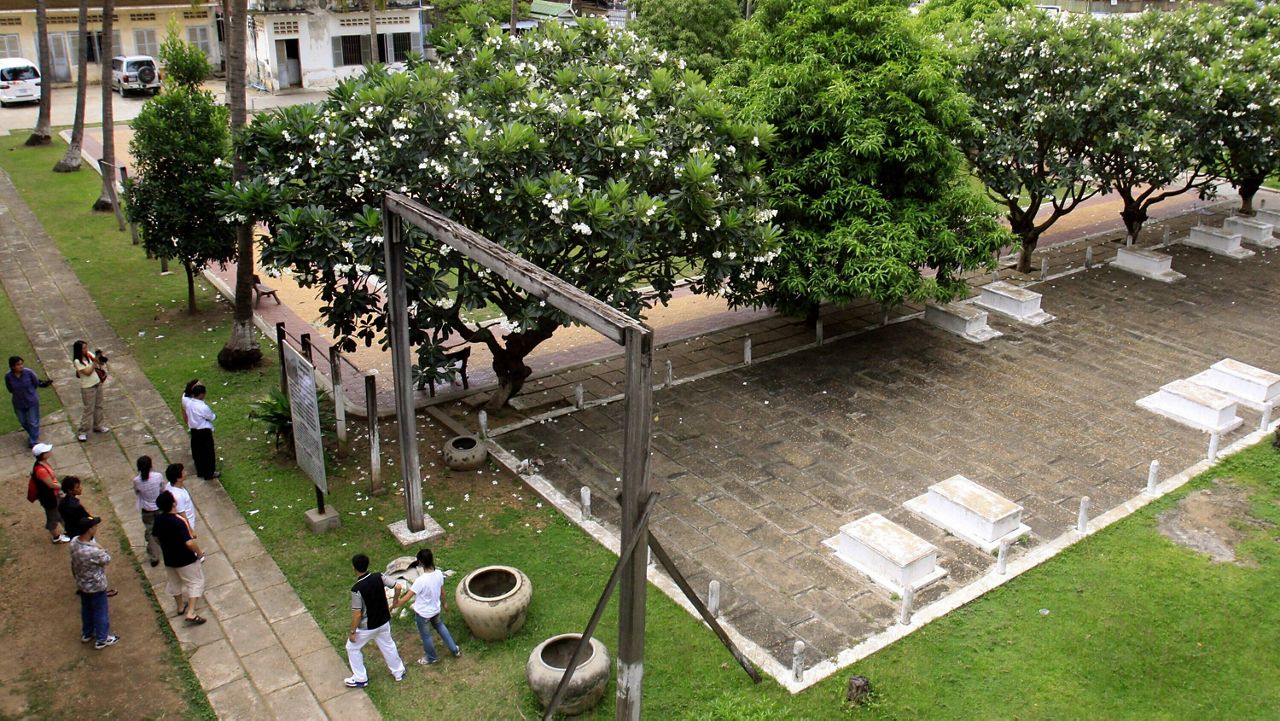 Tourists take their tour at the grave side in the former Pol Pot 's notorious S-21 prison, known Tuol Sleng genocide museum in Phnom Penh, Cambodia, Sunday, July 19, 2009. (AP Photo/Heng Sinith, File)