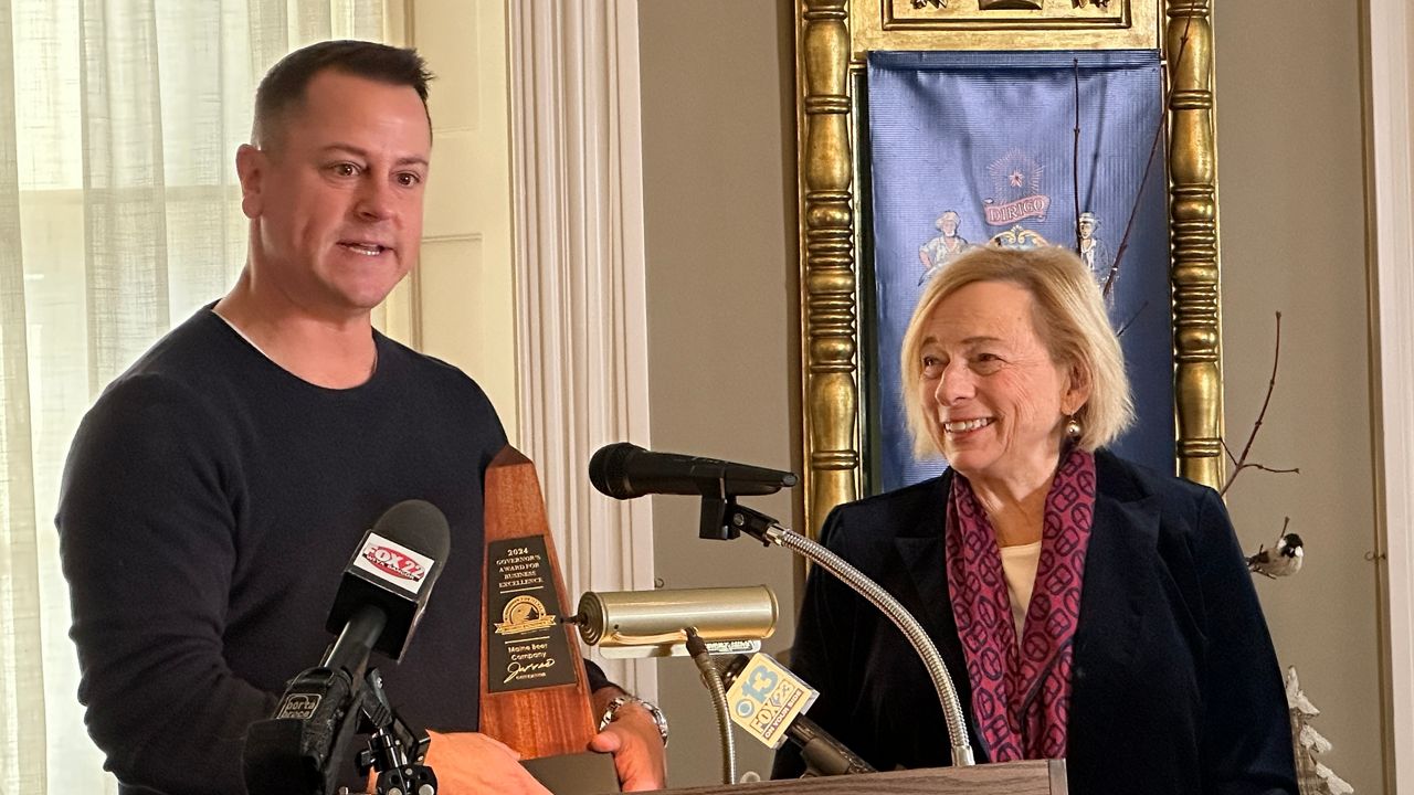 Dan Kleban, owner of Maine Beer Co., accepts an award for business innovation from Gov. Janet Mills Tuesday at the Blaine House. (Spectrum News/Susan Cover)