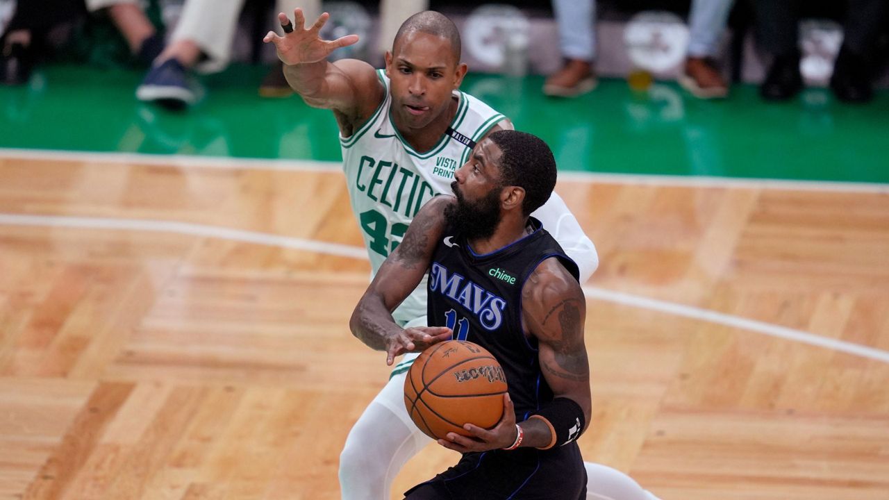 Dallas Mavericks guard Kyrie Irving drives toward the basket as Boston Celtics center Al Horford (42) defends during the first half of Game 1 of basketball's NBA Finals on Thursday, June 6, 2024, in Boston. (AP Photo/Charles Krupa)