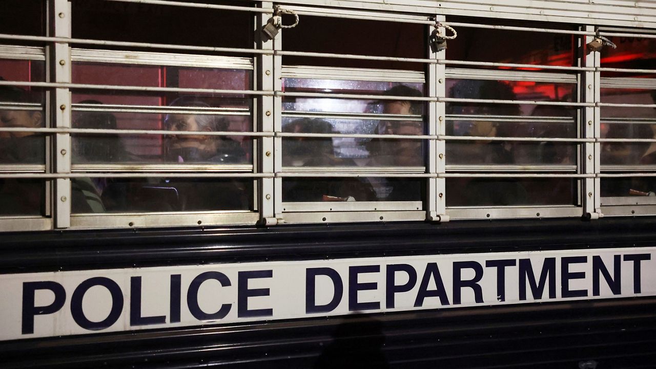 People sit in a Los Angeles Police Department bus after being arrested during a protest on Wednesday, June 11, 2025, in Los Angeles. (AP Photo/Ethan Swope)