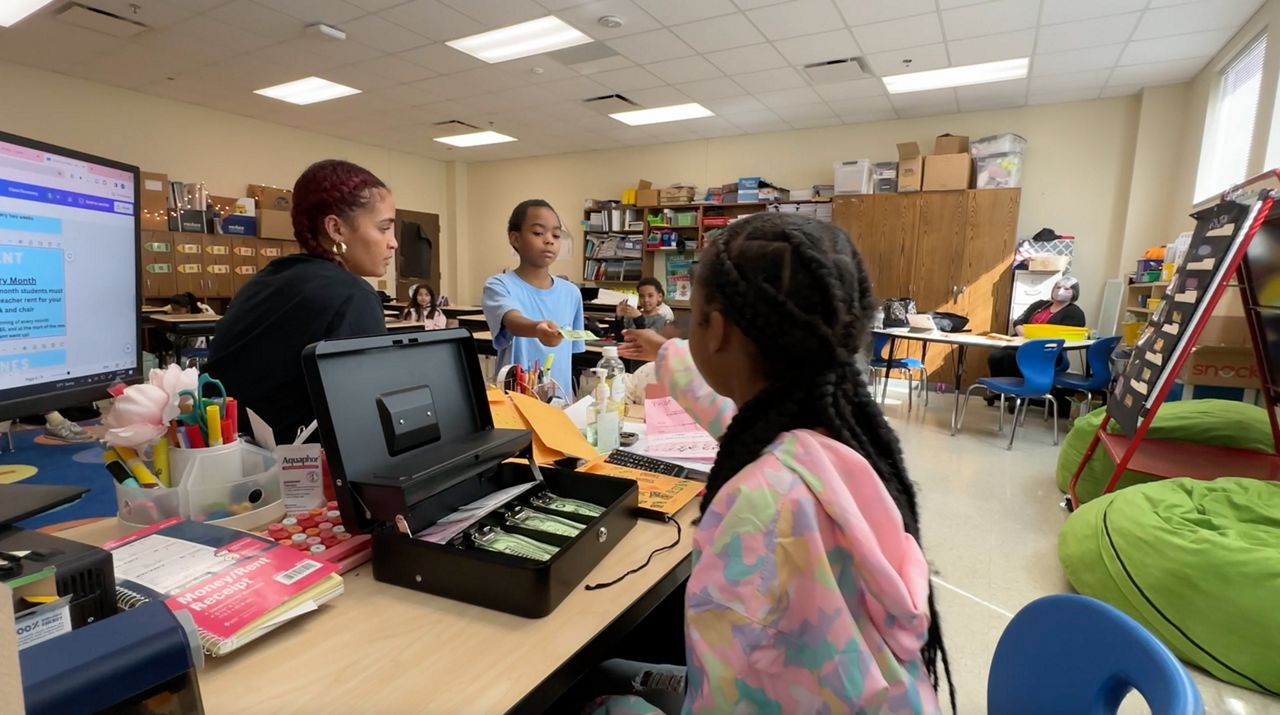 Teacher using 'Lattimore Bucks' to teach personal finance