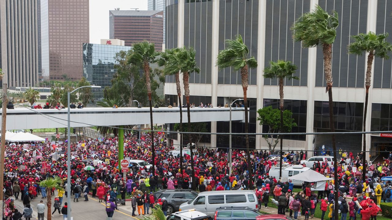 Thousands of Los Angeles Unified School District teachers and Service Employees International Union 99 (SEIU) members rally outside the LAUSD headquarters in Los Angeles on Tuesday. (AP Photo/Damian Dovarganes)