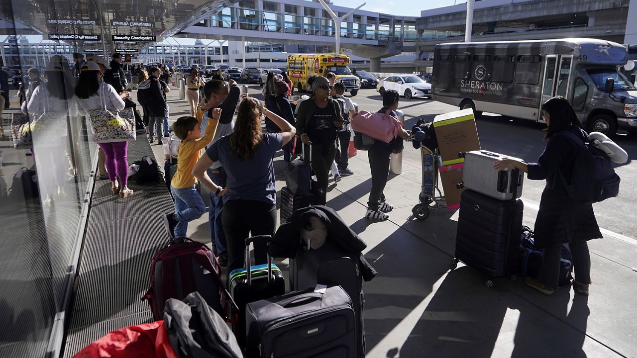 Holiday travelers wait for ground transportation during the week of Thanksgiving, Wednesday, Nov. 22, 2023, at Los Angeles International Airport in Los Angeles (AP Photo/Damian Dovarganes)