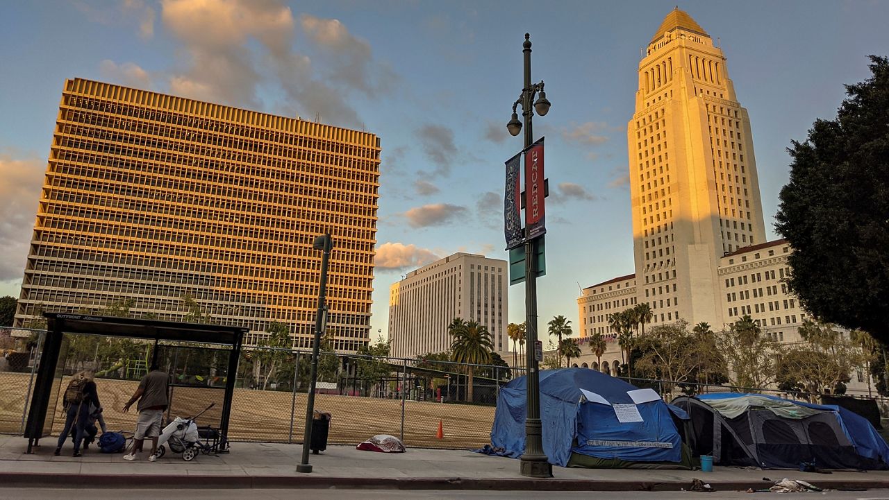 Homeless people await to enter the Midnight Mission late afternoon downtown Los Angeles on Friday, March 22, 2024. (AP Photo/Damian Dovarganes)