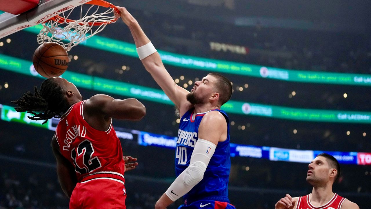 Los Angeles Clippers center Ivica Zubac (40) dunks over Chicago Bulls guard Ayo Dosunmu (12) as Bulls center Nikola Vucevic, righgt, watches during the first half of an NBA basketball game in Los Angeles, Saturday, March 9, 2024. (AP Photo/Eric Thayer)