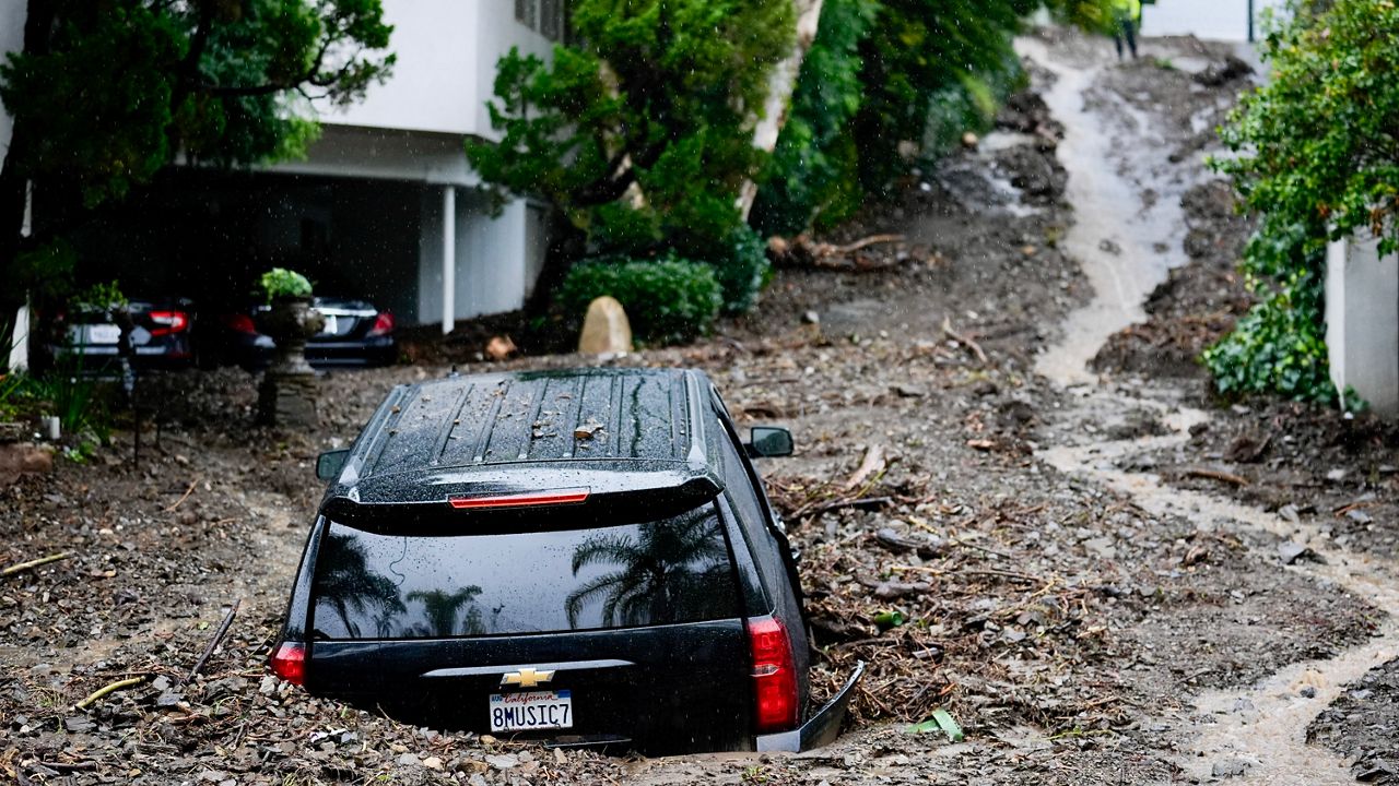 An SUV sits buried by a mudslide, Monday, Feb. 5, 2024, in the Beverly Crest area of Los Angeles. (AP Photo/Marcio Jose Sanchez)
