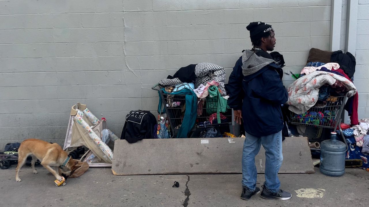 Homeless people sleep near Los Angeles City Hall, right, in downtown Los Angeles on March 27, 2020. (AP Photo/Damian Dovarganes, File)