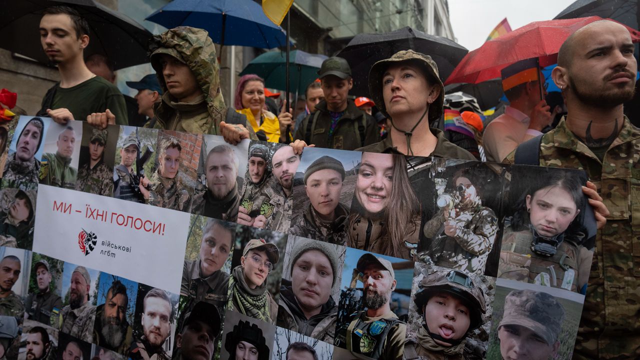 Soldiers hold portraits of LGBT Ukrainian servicemen, who are fighting on the frontline, with the poster reading, "We are their voices," in Kyiv, Ukraine, Sunday, June 16, 2024. Several hundred LGBT Ukrainian servicemen and other protesters joined the pride march in central Kyiv Sunday seeking legal reforms to allow people in same-sex partnerships to take medical decisions for wounded soldiers and bury victims of the war with Russia that extended across Ukraine more than two years ago. (AP Photo/Efrem Lukatsky)