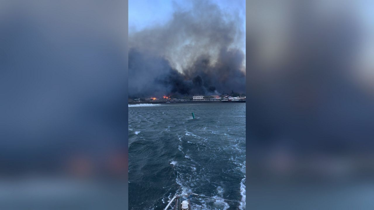 In this photo provided by Brantin Stevens smoke fill the air from wild fires at Lahaina harbor on Tuesday, Aug. 8, 2023 in Hawaii. Fire was widespread in Lahaina Town, including on Front Street, a popular shopping and dining area, County of Maui spokesperson Mahina Martin said by phone early Wednesday. Traffic has been very heavy as people try to evacuate the area, and officials asked people who weren’t in an evacuation area to shelter in place to avoid adding to the traffic, she said. (Brantin Stevens via AP)