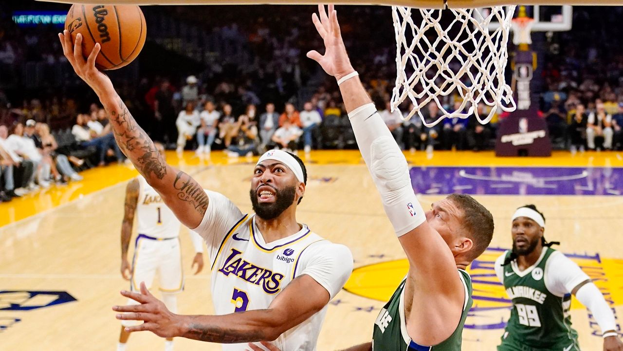 Los Angeles Lakers forward Anthony Davis, left, shoots as Milwaukee Bucks center Brook Lopez defends during the first half of an NBA preseason basketball game Sunday, Oct. 15, 2023, in Los Angeles. (AP Photo/Mark J. Terrill)