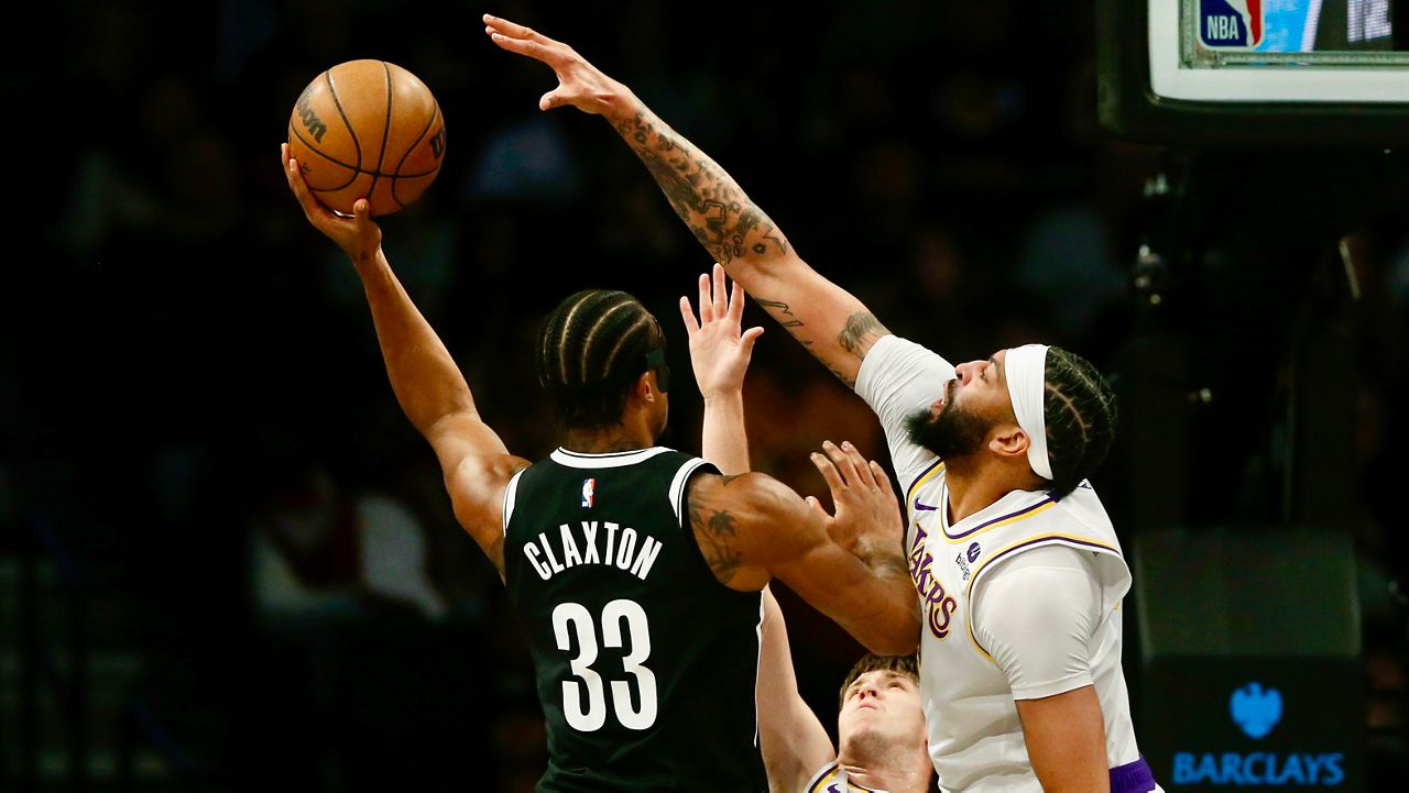 Brooklyn Nets center Nic Claxton, left, is defended by Los Angeles Lakers forward Anthony Thomas during the first half of an NBA basketball game Sunday, March 31, 2024, in New York. (AP Photo/John Munson)