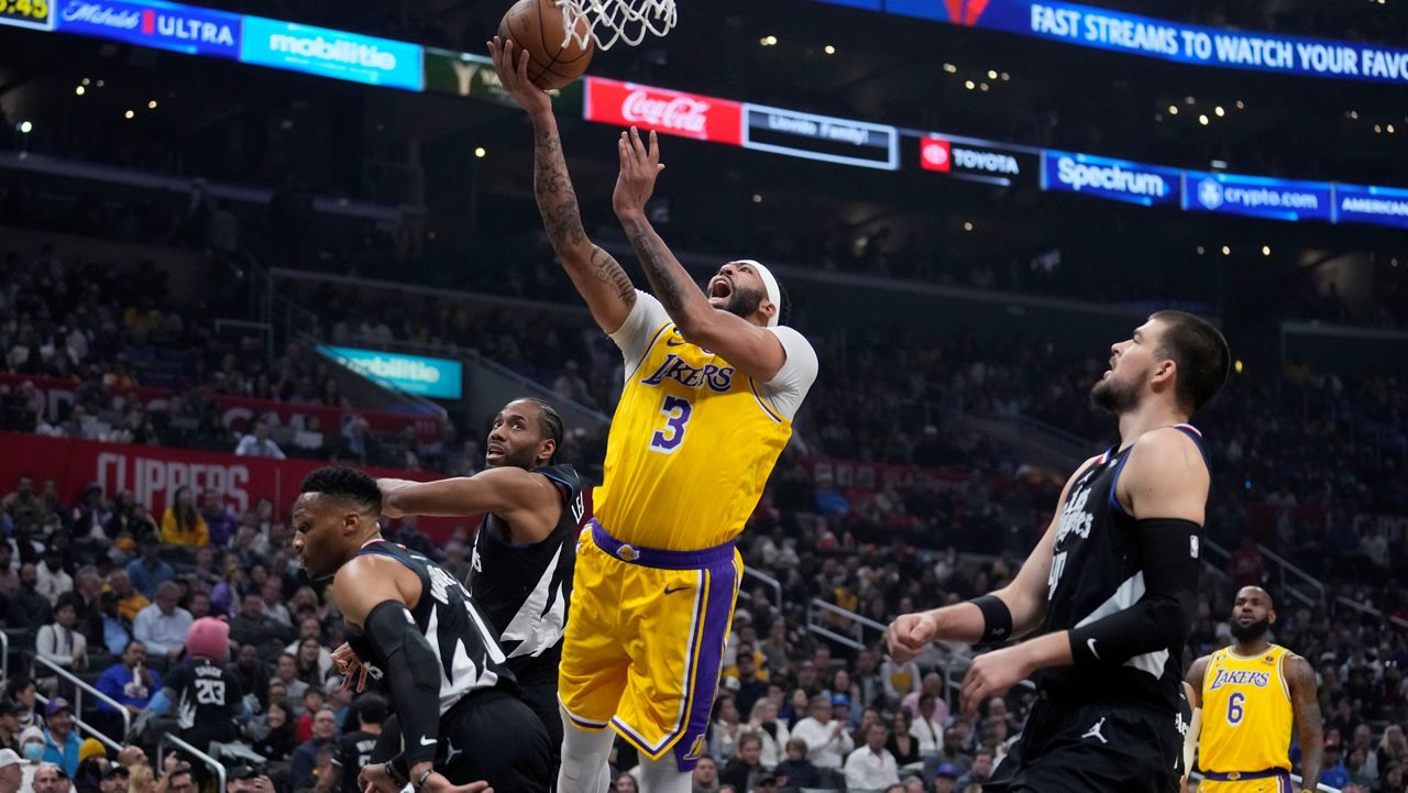 Los Angeles Lakers forward Anthony Davis (3) shoots from between LA Clippers center Ivica Zubac, right, forward Kawhi Leonard, center, and guard Russell Westbrook, left, during the first half of an NBA basketball game Wednesday in LA. (AP Photo/Marcio Jose Sanchez)