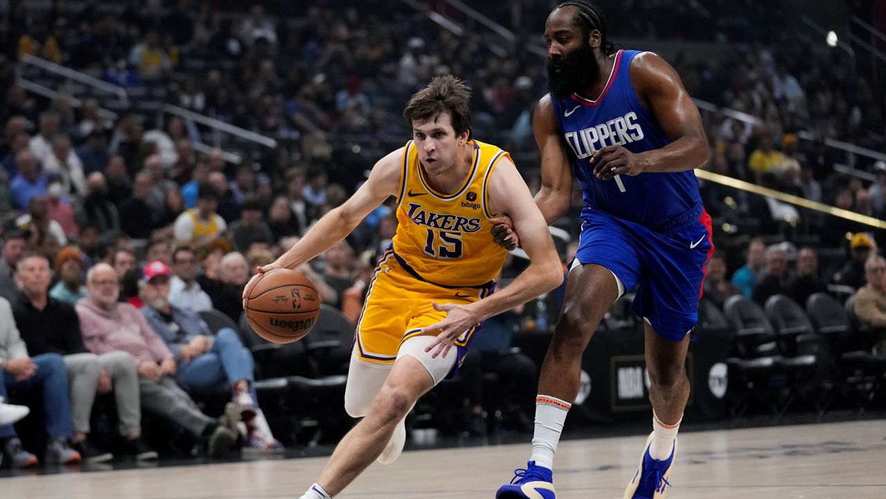 Los Angeles Lakers guard Austin Reaves (15) controls the ball against Los Angeles Clippers guard James Harden (1) during the first half of an NBA basketball game in Los Angeles, Tuesday, Jan. 23, 2024. (AP Photo/Ashley Landis)