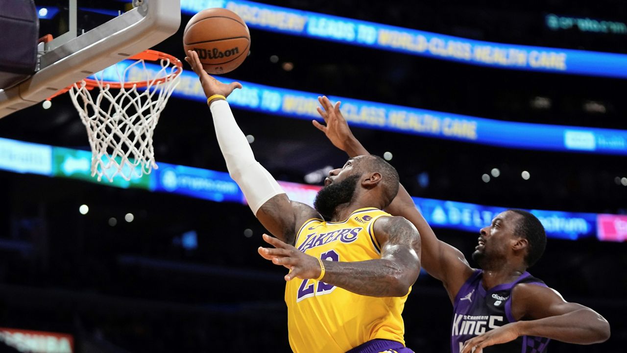 Los Angeles Lakers forward LeBron James, left, shoots as Sacramento Kings forward Harrison Barnes defends during the first half of an NBA basketball game Wednesday, Nov. 15, 2023, in Los Angeles. (AP Photo/Mark J. Terrill)